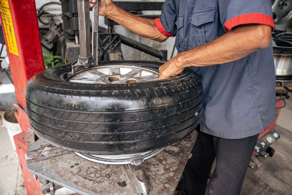 Mechanic performing tire repair with mounting machine.