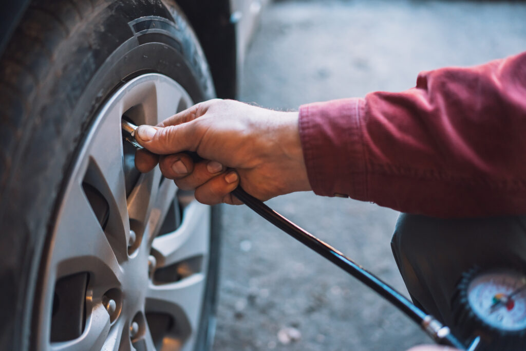 Mechanic checking tire air pressure during tire repair.