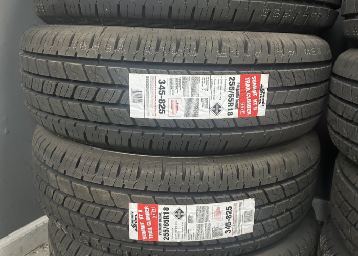 A stack of tires adorned with various colorful stickers, showcasing different designs and messages.